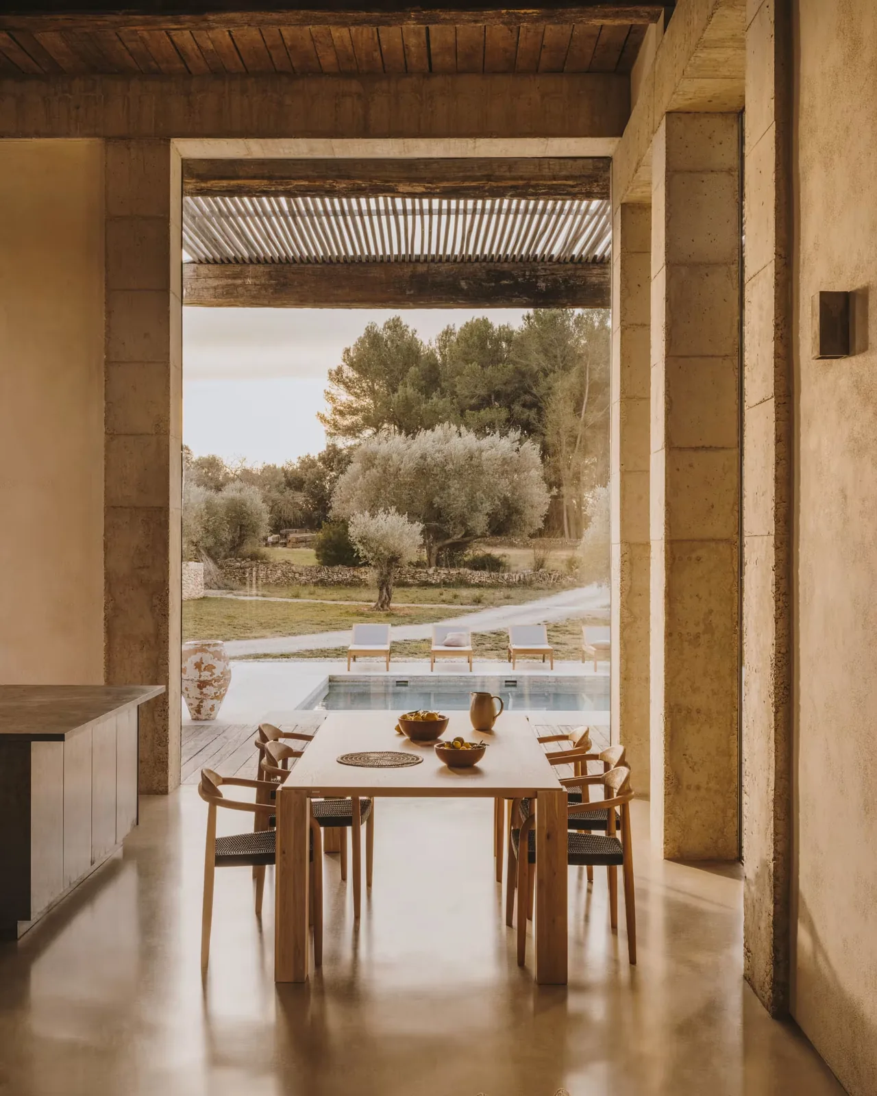Zona pranzo con tavolo e sedie in legno a noleggio, vista sulla piscina